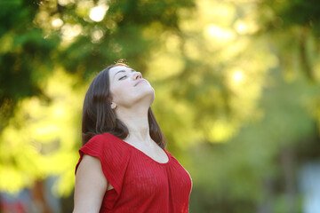 Relaxed woman in a park breathing fresh air