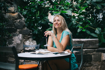 Happy woman enjoying creativity time for perform author's journalistic content sitting in street...