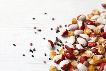 Mixed vegetable seeds on white wooden background, closeup