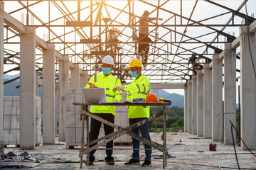 Engineering and supervisor working together in the construction site and masked