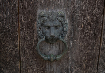 lion's head door knocker in an old house in the village of san salvatore in cabras, west sardinia
