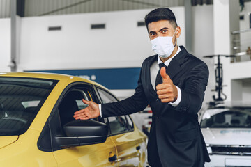 Man car dealer wearing protective medical mask on his working place