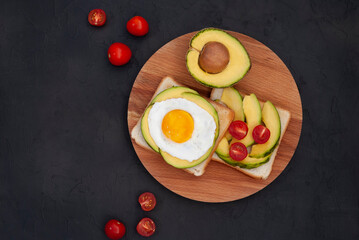 Healthy brekfast toasts with avocado on the black stone background flat lay mock-up with copy space