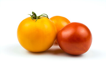 Ripe yellow and red tomatoes close-up isolated on a white background.
