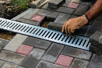 Installation of light metal grating and gutters for drainage of rainwater and paving slabs....