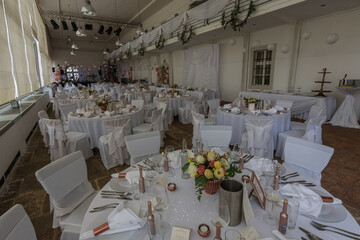 many tables with chairs in a room for a wedding