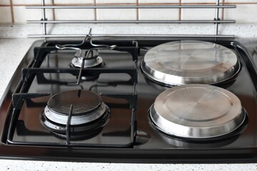 Clean surface of electric and gas hob, selective focus. Domestic kitchen. Kitchen stove top view. Stainless steel gas and electric hob. 