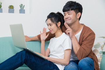 Happy young couple talking through the computer with video chat.