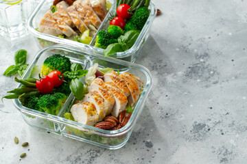 Healthy meal prep containers with green beans, chicken breast and broccoli. A set of food for keto...
