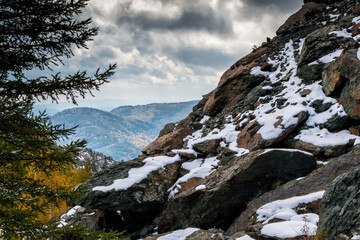 Rock, mountains and autumn forest in cloudy weather