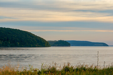 Several mountains at sunset by the sea.
