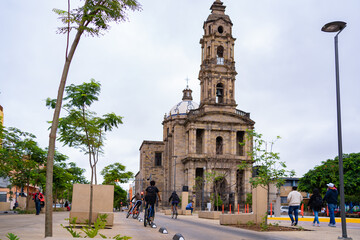 Fototapeta premium Varios muchachos manejan sus bicicletas al lado del parque Reforma en frente del Templo San José de Gracia.