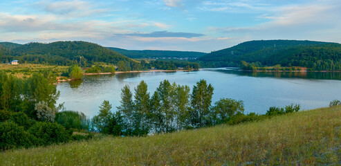 Bay against the backdrop of mountains and blue sky with clouds. Nature background.