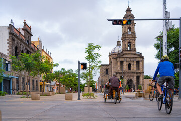 Los ciclistas van por la avenida Alcalde en el centro histórico de Guadalajara.