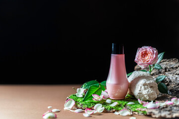 Pink tube of cosmetic product on a creative stone podium on a dark background. Trendy natural spa concept.