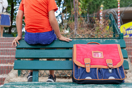 &eacute;colier et son cartable sur un banc