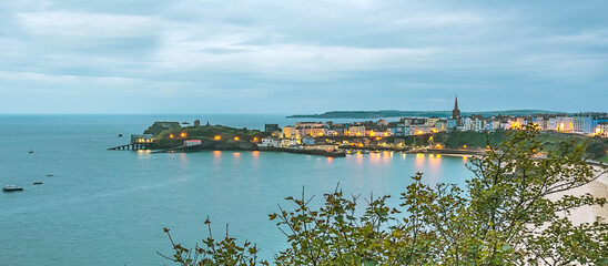 A view across Tenby peninsula with Caldey island visible at sunrise in Autumn