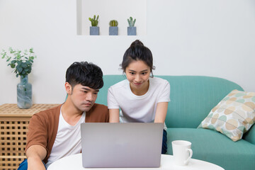Asian woman and man working on laptop.