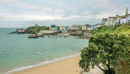 Fototapeta na wymiar A view from North Cliff of the multi-coloured Georgian town of Tenby, the harbour and Goscar Rock at sunrise in Autumn