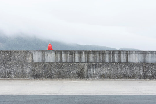 thoughtful person sitting on a wall
