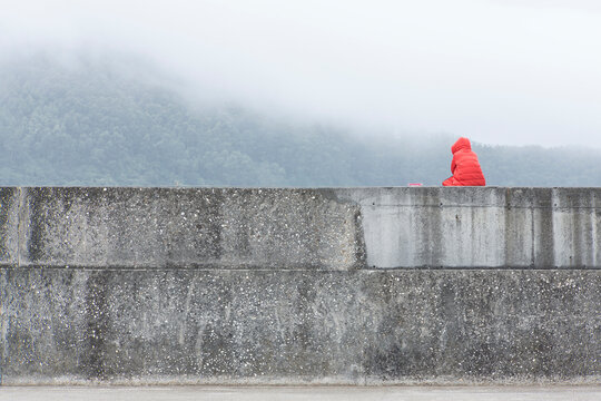 stone wall with a person sitting on it contemplating a landscape