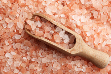 Fototapeta na wymiar Pink himalayan salt and wooden scoop as background, top view