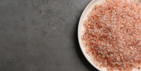 Pink himalayan salt on grey table, top view. Space for text