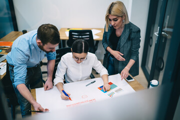 Colleagues working on sales chart in office