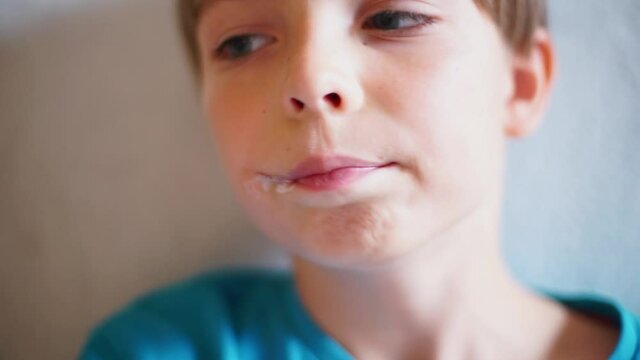 Close-up of a boy eating ice cream in his spare time. A frozen dessert on a hot day. Relaxation of teen stress.