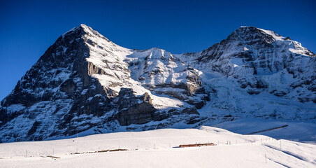 Train in the Jungfraubahn passing through the snow and in front of a peak.