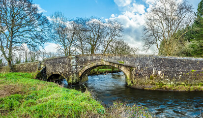 Fototapeta na wymiar A panorama view across River Syfynwy, Wales towards the Gelli bridge, an eighteenth-century, grade 2 listed bridge
