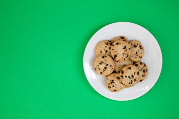 A Plate of Chocolate Chip Cookies on a  Green Background