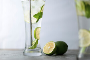 Cold refreshing beverage with sliced lime ripes and ice reverse light image in studio with white illuminated background
