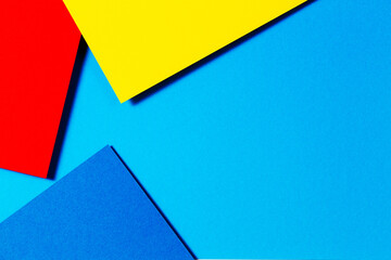 Abstract color papers geometry flat lay composition background with blue, yellow and red color tones