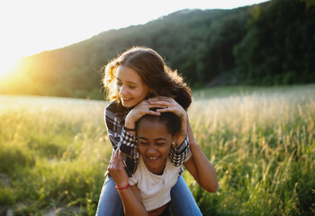 Front view of young teenager girls friends outdoors in nature, having fun.