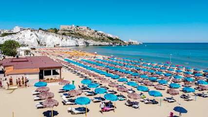 Aerial view of the Spiaggia di Castello, south of Vieste on the Gargano Peninsula in Italy - Alignements of umbrellas in summer for holiday goers in the Adriatic Sea