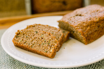 Delicious Slices of Homemade Zucchini Bread on a White Plate in a Kitchen. 