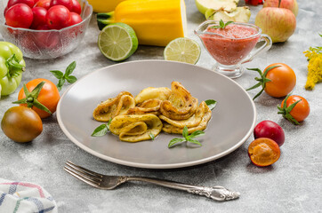 Fried zucchini on a gray plate with homemade sauce