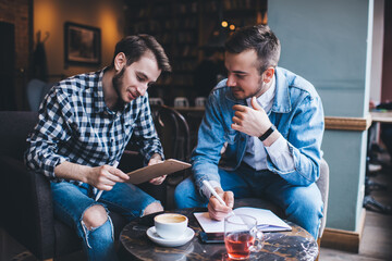Male colleagues working in cafe