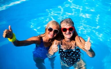 High angle view of cheerful senior women in swimming pool outdoors in backyard.