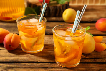 Delicious refreshing drink with apricot on wooden table, closeup