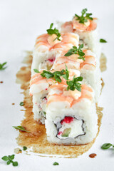 Japanese cuisine, fresh sushi on a light background. Assorted sushi with wasabi, soy sauce and ginger