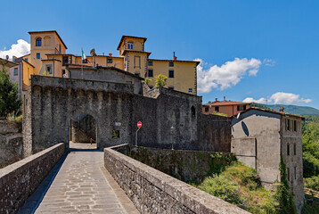 Fototapeta na wymiar Blick auf die Altstadt mit Stadtmauer und Stadttor von Castelnuovo di Garfagnana in der Toskana in Italien 