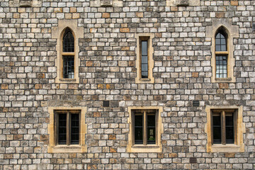 Obraz premium Old stony wall in England with gothic windows, England