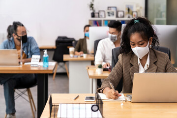 African office worker with asian team in new normal social distance office