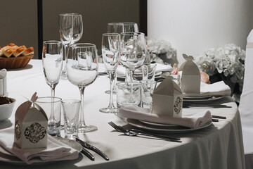 tableware Glasses, flower fork, knife served for dinner in restaurant with cozy interior