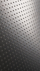 Dark metallic mobile phone wallpaper. Perforated aluminum surface with many holes. Abstract industrial tech background. Vertical metal backdrop. Macro