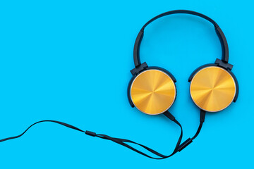 Modern orange headphone on blue background. Music concept.