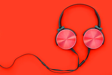 Modern red headphone on red background. Music concept.