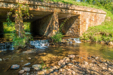 Fototapeta na wymiar Stone bridge with a creek